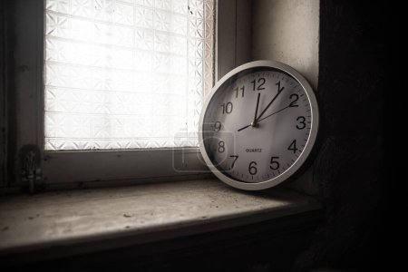 Téléchargez les photos : Time concept. Old rustic wall clock on grunge dirty windowsill. Studio shot. - en image libre de droit