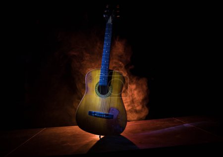 Photo for Music concept. Acoustic guitar isolated on a dark background under beam of light with smoke with copy space. Guitar Strings, close up. Selective focus. - Royalty Free Image