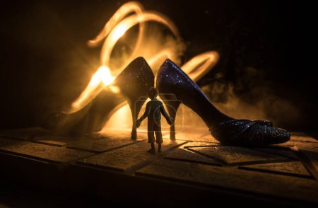 Foto de Decoración de obra. Silueta de un tacón alto zapatos de mujer en la oscuridad. Concepto de poder femenino o dominación femenina. Enfoque selectivo - Imagen libre de derechos