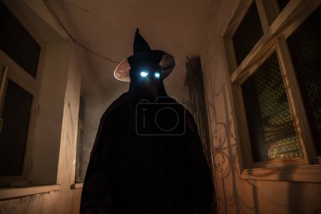 Photo for Halloween concept. Creepy silhouette in the dark corridor with pumpkin head. Toned light with fog on background. Selective focus. Long shutter shot - Royalty Free Image