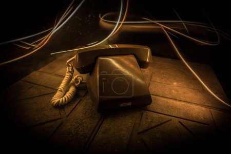 Téléchargez les photos : Vieux téléphone sans numéros sur la vieille planche de bois avec fond sombre art avec brouillard et lumière tonique. espace vide. Concentration sélective - en image libre de droit