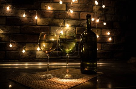 Foto de Copa de vino sobre fondo de barra oscura de baja luz. Coloridas copas de vino con luz en la parte trasera en enfoque selectivo - Imagen libre de derechos