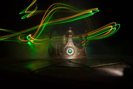 Foto de Imagen de la llave baja de la corona de reyes hermosos sobre tabla de madera. filtrado vintage. época medieval de fantasía. Enfoque selectivo. Retroiluminación colorida - Imagen libre de derechos
