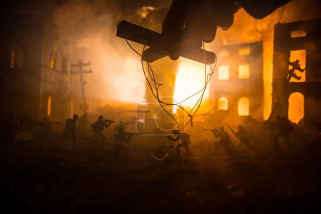 Photo for Concept of war or manipulation with global politics. The puppeteer controls soldiers. Night battle scene. Military fighting silhouettes in destroyed city. Selective focus - Royalty Free Image