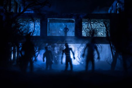 Foto de Silueta de persona de pie en el bosque oscuro con luz. Concepto de Halloween de horror. silueta extraña en el edificio abandonado - Imagen libre de derechos