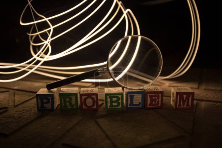 Photo for Loupe analysing the word "problem" on wooden cubes in dark backgroung. Selective focus - Royalty Free Image