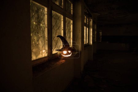 Foto de Calabaza de Halloween miedo en la ventana de la casa mística por la noche o calabaza de Halloween en la noche en la habitación abandonada con ventana. Enfoque selectivo - Imagen libre de derechos