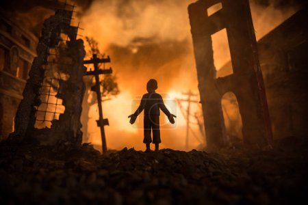 Photo for Artwork decoration. A man standing on a road of burnt up city. Apocalyptic view of city downtown as disaster film poster concept. Night scene. City destroyed by war. Selective focus - Royalty Free Image