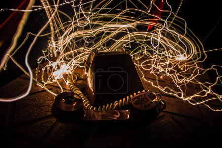 Téléchargez les photos : Vieux téléphone sans numéros sur la vieille planche de bois avec fond sombre art avec brouillard et lumière tonique. espace vide. Concentration sélective - en image libre de droit