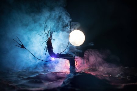 Foto de Silueta de espeluznante árbol de Halloween sobre oscuro fondo nebuloso tonificado con luna en la parte posterior. Espeluznante bosque muerto de invierno por la noche. enfoque selectivo - Imagen libre de derechos