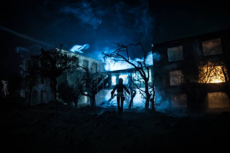 Foto de Silueta de persona de pie en el bosque oscuro con luz. Concepto de Halloween de horror. silueta extraña en el edificio abandonado - Imagen libre de derechos