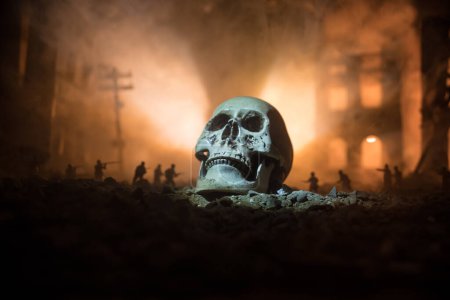 Photo for Concept of death soldiers during the war. Giant human skull with military fighting silhouettes in destroyed city. Selective focus - Royalty Free Image
