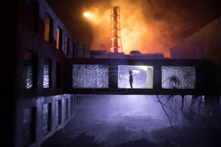 Téléchargez les photos : Décoration artistique créative. Centrale nucléaire de Tchernobyl la nuit. Aménagement de la centrale abandonnée de Tchernobyl après l'explosion du réacteur nucléaire. Silhouette d'homme dans la fenêtre. Concentration sélective - en image libre de droit