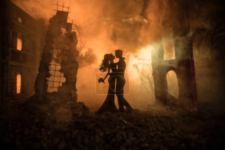 Foto de Nuclear war apocalypse and love until death concept. Romantic couple during atomic war. Creative artwork decoration in dark. Selective focus - Imagen libre de derechos
