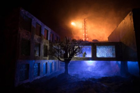 Téléchargez les photos : Décoration artistique créative. Centrale nucléaire de Tchernobyl la nuit. Aménagement de la centrale abandonnée de Tchernobyl après l'explosion du réacteur nucléaire. Silhouette d'homme dans la fenêtre. Concentration sélective - en image libre de droit