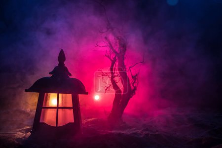 Foto de Silueta de espeluznante árbol de Halloween sobre oscuro fondo nebuloso tonificado con luna en la parte posterior. Espeluznante bosque muerto de invierno por la noche. enfoque selectivo - Imagen libre de derechos