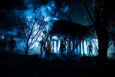 Téléchargez les photos : Silhouette de personne debout dans la forêt sombre avec de la lumière. Horreur concept d'Halloween. étrange silhouette dans un village sombre et effrayant - en image libre de droit