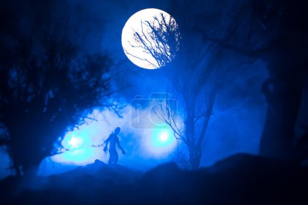 Photo for Silhouette of person standing in the dark forest with light. Horror halloween concept. strange silhouette in a dark spooky village - Royalty Free Image