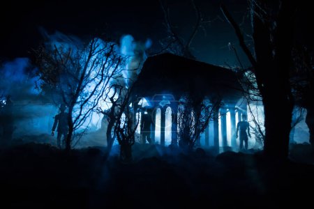 Foto de Silueta de persona de pie en el bosque oscuro con luz. Concepto de Halloween de horror. extraña silueta en un oscuro pueblo espeluznante - Imagen libre de derechos