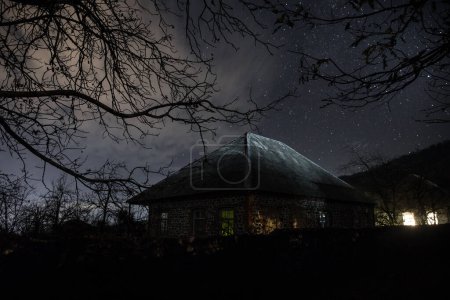 Photo for Embrace the eerie ambiance of a moonlit night as an ancient, haunted mansion emerges from the dense, mist-covered forest, surrounded by the whispers of the dead trees - Royalty Free Image