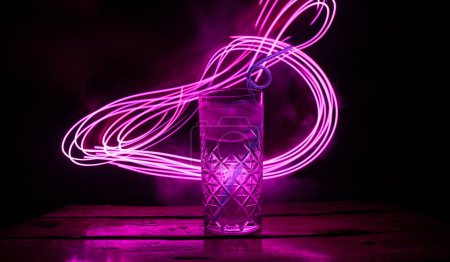 Foto de Cóctel colorido en vidrio sobre fondo oscuro o vasos de cócteles en el fondo del bar.Club de fiesta de entretenimiento. Luz mixta - Imagen libre de derechos