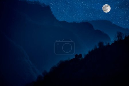 Foto de Mountain Road a través del bosque en una noche de luna llena. Paisaje nocturno escénico de carretera rural por la noche con luna grande. Azerbaiyán naturaleza - Imagen libre de derechos