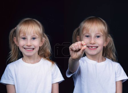 Photo for Happy blondy smiling girl with all teeth on one photo and holding a fallen frontal baby tooth on another photo against black background. - Royalty Free Image