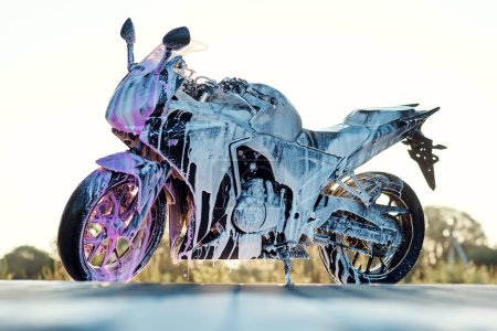 Foto de Elegante motocicleta deportiva con espuma en el auto-servicio de lavado de coches. - Imagen libre de derechos