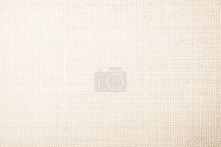 Foto de Lona de arpillera de tela de saco vacilante yute textura tejida patrón de fondo en blanco crema beige claro color marrón. Tejido natural de lino de fibra y textura de tela de algodón como vacío limpio para la decoración. - Imagen libre de derechos