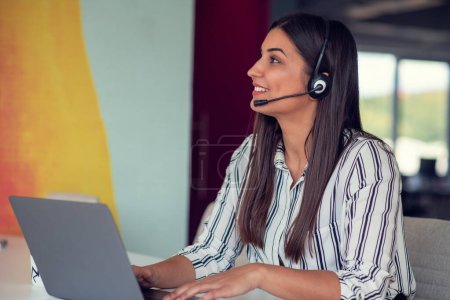 Photo for Young friendly operator woman agent with headsets working in a call centre - Royalty Free Image