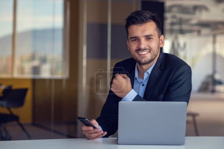 Photo for Man Working At Laptop In Contemporary Office. - Royalty Free Image