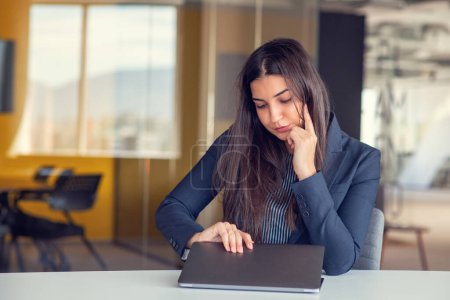 Téléchargez les photos : Femme d'affaires bâillant tout en travaillant avec un ordinateur portable dans le bureau, une femme dans le style de vie de bureau occasionnel concept - en image libre de droit