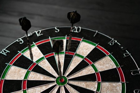 Photo for Three darts hit the dartboard. Lucky - one of the darts hits the bulls eye. The concept of winning and luck. Close-up, angled view - Royalty Free Image