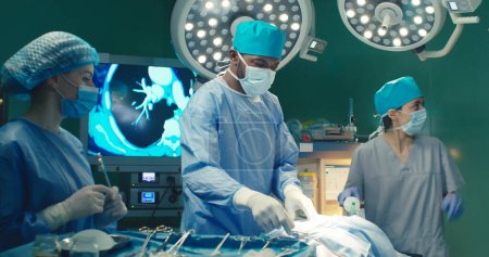 Diversité ethnique. Médecin afro-américain effectue une opération chirurgicale dans un hôpital moderne. Travail d'équipe de chirurgiens médicaux professionnels en salle d'opération. Concept de soins de hélium et de traitement médical.