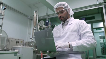 Téléchargez les photos : Portrait of a man scientist in uniform working in curative laboratory for chemical and biomedical experiment - en image libre de droit