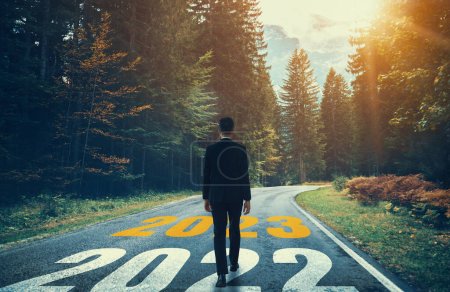 El viaje de año nuevo 2023 y el concepto de visión futura. Empresario que viaja por carretera que conduce a la celebración feliz año nuevo a principios de 2021 para un comienzo fresco y exitoso .