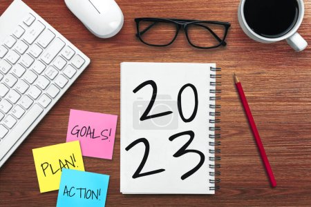 Téléchargez les photos : 2023 Happy New Year Resolution Goal List and Plans Setting - Bureau d'affaires avec un cahier écrit sur la liste des objectifs et des résolutions du nouvel an. Changement et concept de détermination. - en image libre de droit