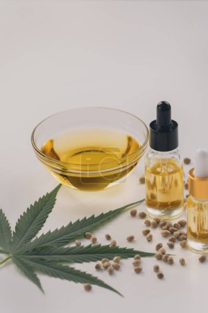 Photo for Sets of legalized marijuana features with CBD oil in bottle with dropper lid, sativa green hemp, and hemp seeds. Cannabis product for copyspace and advertisement. - Royalty Free Image