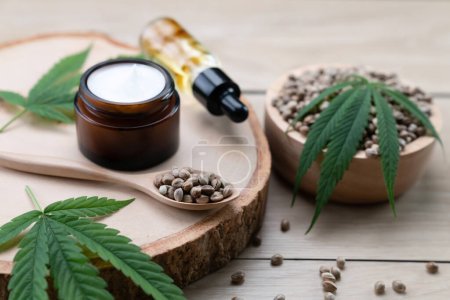 Cannabis- und Kosmetikkonzepte mit CBD-Ölflaschen, Sahnegefäßen und einer hölzernen Schale mit Hanfsamen. Legalisiertes Cannabis für Hautpflegeprodukte.