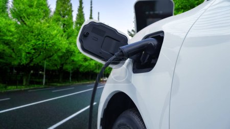 Concepto de viaje progresivo de parada de vehículo eléctrico para recargar energía de la estación de carga en la zona remota antes de llegar a destino, coche EV alimentado por energía renovable y limpia para el medio ambiente verde