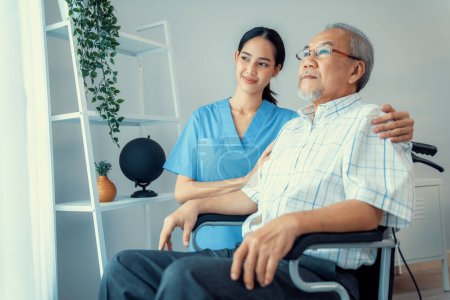 Foto de Caring nurse and a contented senior man in a wheel chair at home, nursing house. Medical for elderly senior, home care for pensioners. - Imagen libre de derechos