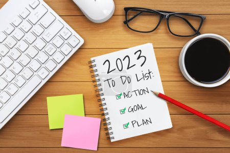 Téléchargez les photos : 2023 Happy New Year Resolution Goal List and Plans Setting - Bureau d'affaires avec un cahier écrit sur la liste des objectifs et des résolutions du nouvel an. Changement et concept de détermination. - en image libre de droit