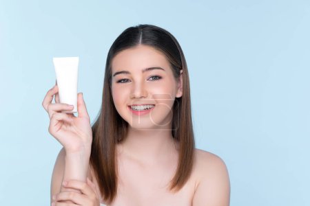 Photo for Young charming girl with natural beauty, perfect smooth skin hold lotion, cream, moisturizer tube. Beautiful girl show skincare product smiling on isolated background. - Royalty Free Image