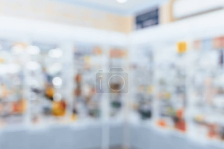 Pharmacy blurred abstract background qualified drug, medicinal product on shelf background. Blurry light tone wallpaper of drugstores interior medications displayed on shelves for healthcare concept.