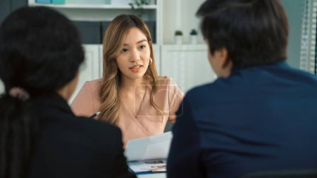 Foto de A young female asian candidate tries to impress her interviewer by being competent. International company, multicultural environment in workplace. - Imagen libre de derechos