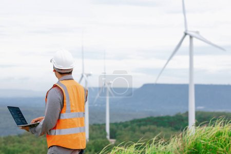 Ingenieur, der an einem Windpark auf einem Hügel oder Berg im ländlichen Raum arbeitet. Progressives Ideal für die zukünftige Produktion erneuerbarer, nachhaltiger Energie. Energieerzeugung aus Windenergieanlagen.