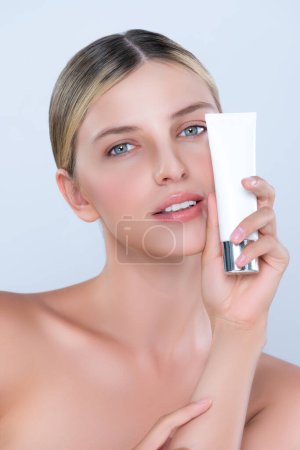 Photo for Alluring beautiful perfect cosmetic skin woman portrait hold mockup tube cream or moisturizer for skincare treatment, anti-aging product in isolated background. Natural healthy skin model concept. - Royalty Free Image