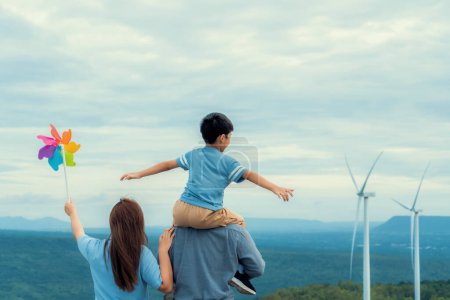 Photo for Progressive happy family enjoying their time at wind farm for green energy production concept. Wind turbine generators provide clean renewable energy for eco-friendly purposes. - Royalty Free Image