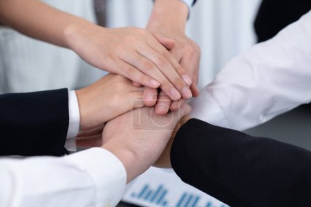 Foto de Top view closeup business team of suit-clad businesspeople join hand stack together. Colleague collaborate and work together to promote harmony and teamwork concept in office workplace. - Imagen libre de derechos