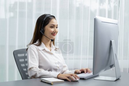 Asiatisches Callcenter mit Headset und Mikrofon an ihrem Laptop. Betreiberinnen bieten einen außergewöhnlichen Kundenservice. Supportive Call Center Agent hilft Kunden auf Anfrage. Enthusiastisch
